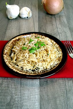 Easy Rice Pilaf on a brown plate with a red napkin in the background