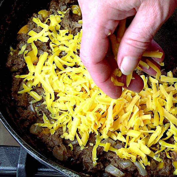 Topping the refried beans with cheese